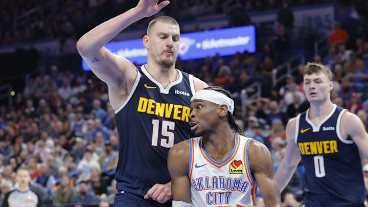 Mar 10, 2025; Oklahoma City, Oklahoma, USA; Denver Nuggets center Nikola Jokic (15) defends a drive by Oklahoma City Thunder guard Shai Gilgeous-Alexander (2) during the second half at Paycom Center.