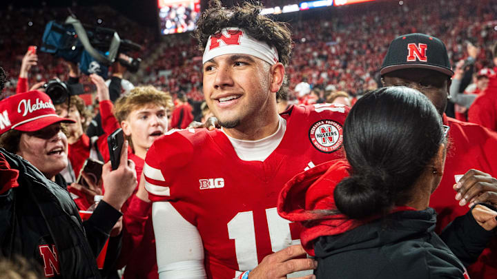 Nov 23, 2024; Lincoln, Nebraska, USA; Nebraska Cornhuskers quarterback Dylan Raiola (15) walks off as fans rush the field after defeating the Wisconsin Badgers at Memorial Stadium. Mandatory Credit: Dylan Widger-Imagn Images