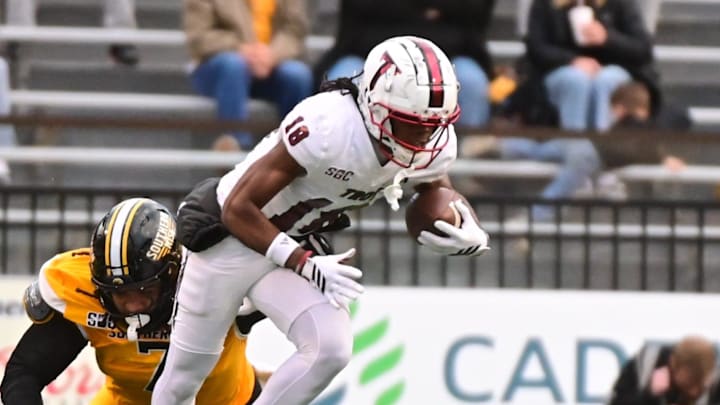 Troy Trojans wide receiver DJ Epps (18) runs the ball while defended by Southern Miss Golden Eagles nose tackle Isaiah Gibson Sr. (7) during a college football game between Southern Miss and Troy at M.M. Roberts Stadium in Hattiesburg, Miss., on Saturday, Nov. 29, 2025. Troy defeated Southern Miss 28-18.