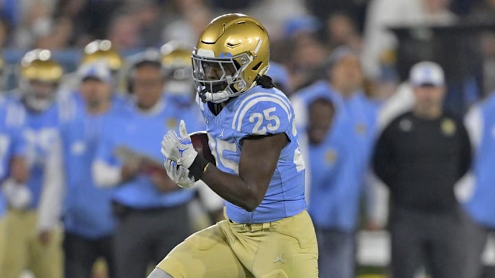 Nov 8, 2024; Pasadena, California, USA;   UCLA Bruins running back T.J. Harden (25) carries for a gain in the first half against the Iowa Hawkeyes at the Rose Bowl. Mandatory Credit: Jayne Kamin-Oncea-Imagn Images