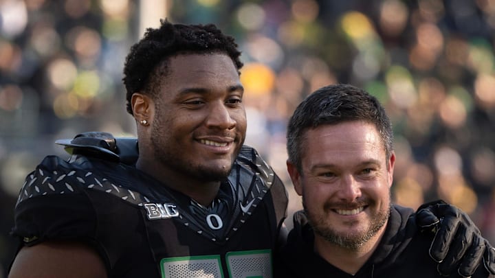 Oregon’s Isaiah World, left, takes a picture with coach Dan Lanning 
