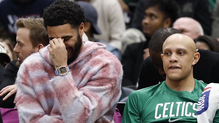 Dec 4, 2025; Washington, District of Columbia, USA; Injured Boston Celtics forward Jayson Tatum (L) reacts on the bench against the Washington Wizards in the second half at Capital One Arena.