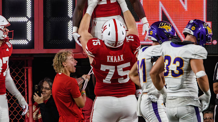 Tyler Knaak (75) lifts Emmett Johnson (21) after his 36-yard touchdown run. Tyler Knaak (75) lifts Emmett Johnson (21) after his 36-yard touchdown run.