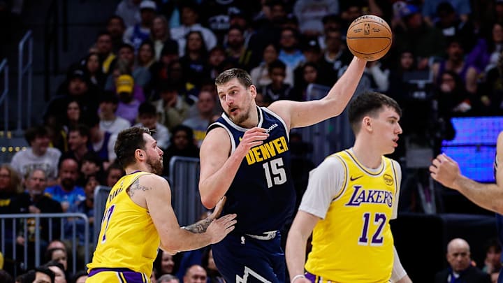 Mar 5, 2026; Denver, Colorado, USA; Denver Nuggets center Nikola Jokic (15) controls the ball under pressure from Los Angeles Lakers guard Luka Doncic (77) as forward Jake LaRavia (12) and guard Jamal Murray (27) defend in the third quarter at Ball Arena. Mandatory Credit: Isaiah J. Downing-Imagn Images