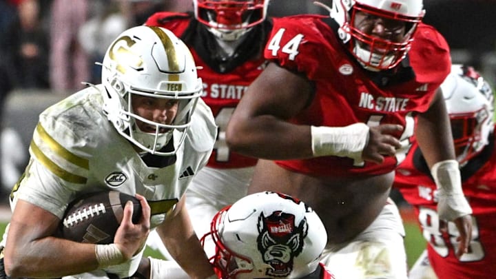Nov 1, 2025; Raleigh, North Carolina, USA; North Carolina State Wolfpack saftey Tristan Teasdell (19) attempts to tackle Georgia Tech Yellow Jackets quarterback Haynes King (10) during the fourth quarter at Carter-Finley Stadium. Mandatory Credit: Zachary Taft-Imagn Images Nov 1, 2025; Raleigh, North Carolina, USA; North Carolina State Wolfpack saftey Tristan Teasdell (19) attempts to tackle Georgia Tech Yellow Jackets quarterback Haynes King (10) during the fourth quarter at Carter-Finley Stadium. Mandatory Credit: Zachary Taft-Imagn Images