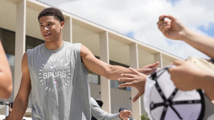 Jun 28, 2025; San Antonio, TX, USA; San Antonio Spurs first round draft pick Carter Bryant greets fans at Victory Capital Performance Center.