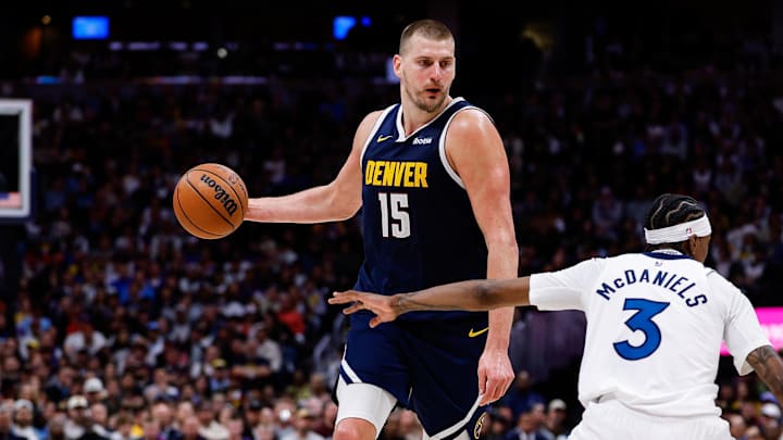 Apr 27, 2026; Denver, Colorado, USA; Denver Nuggets center Nikola Jokic (15) controls the ball as Minnesota Timberwolves forward Jaden McDaniels (3) defends in the third quarter during game five of the first round of the 2026 NBA Playoffs at Ball Arena.