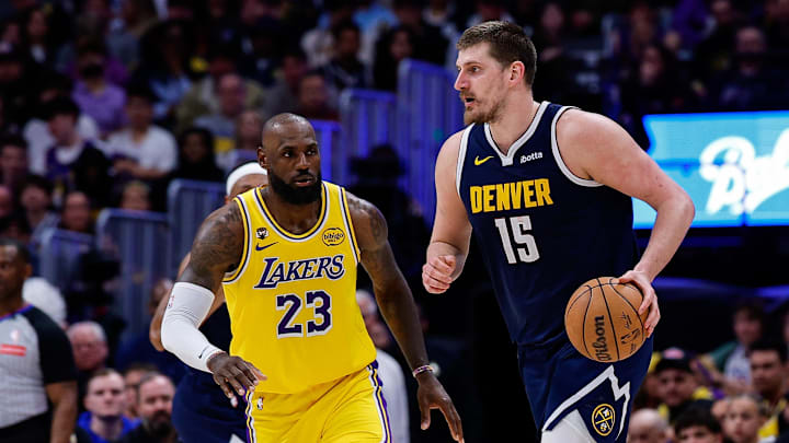 Mar 5, 2026; Denver, Colorado, USA; Denver Nuggets center Nikola Jokic (15) controls the ball as Los Angeles Lakers forward LeBron James (23) guards in the fourth quarter at Ball Arena.