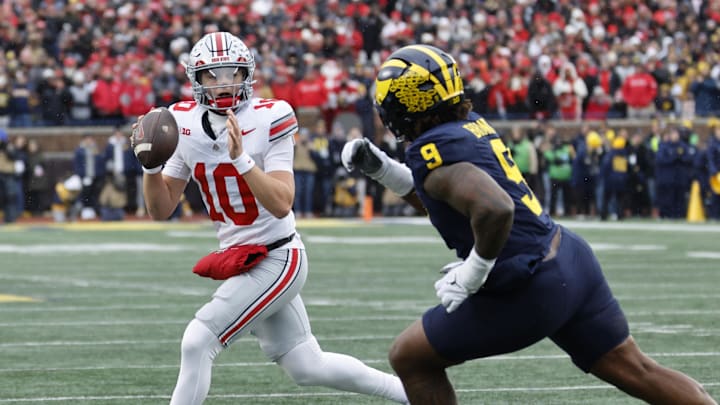 Nov 29, 2025; Ann Arbor, Michigan, USA; Ohio State Buckeyes quarterback Julian Sayin (10) runs the ball pressured by Michigan Wolverines defensive end Cameron Brandt (9) in the first half at Michigan Stadium. Mandatory Credit: Rick Osentoski-Imagn Images