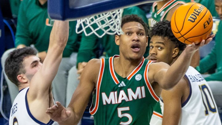 Jan 13, 2026; South Bend, Indiana, USA; Miami (FL) Hurricanes forward Malik Reneau (5) drives past Notre Dame Fighting Irish guard Logan Imes (2) during the second half at Purcell Pavilion at the Joyce Center. Mandatory Credit: Michael Caterina-Imagn Images