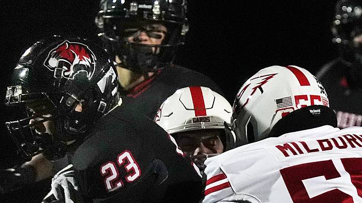 Gilbert's running back/linebacker Tayton Warg (23) battles for a few yard as getting tackle by Newton Cardinals linebacker/offensive line Nick Milburn (55) during the first quarter in the high school football class 4A quarterfinal on Nov. 7, 2025, at Tigers Stadium, Gilbert, Iowa. Gilbert's running back/linebacker Tayton Warg (23) battles for a few yard as getting tackle by Newton Cardinals linebacker/offensive line Nick Milburn (55) during the first quarter in the high school football class 4A quarterfinal on Nov. 7, 2025, at Tigers Stadium, Gilbert, Iowa.