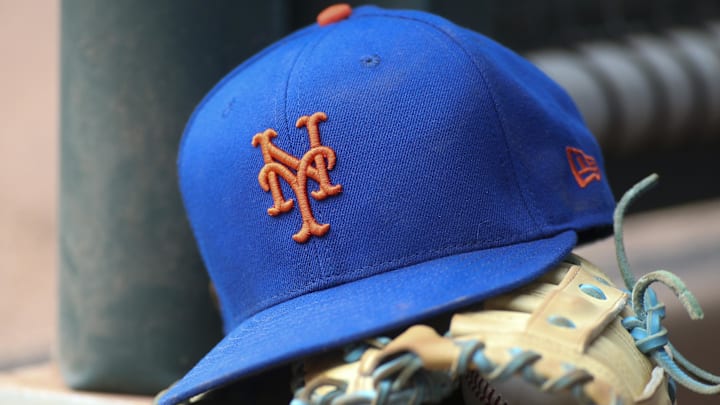 Jul 13, 2022; Atlanta, Georgia, USA; A detailed view of a New York Mets hat and glove in the dugout against the Atlanta Braves in the eighth inning at Truist Park. 