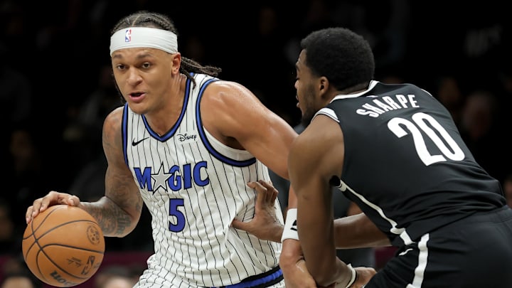 Jan 7, 2026; Brooklyn, New York, USA; Orlando Magic forward Paolo Banchero (5) drives to the basket against Brooklyn Nets center Day'ron Sharpe (20) during the second quarter at Barclays Center. Mandatory Credit: Brad Penner-Imagn Images