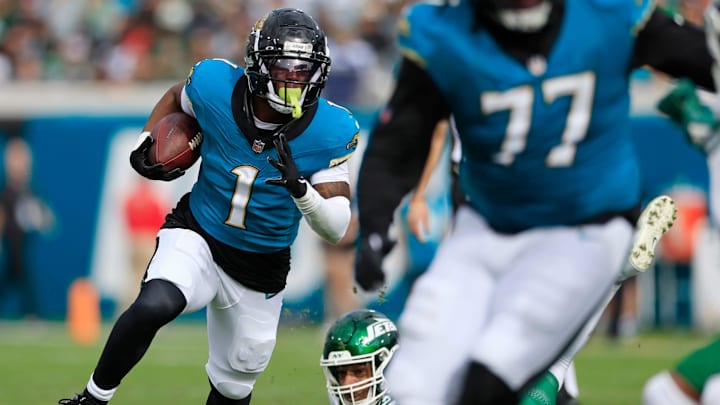 Jacksonville Jaguars running back Travis Etienne Jr. (1) rushes for yards slipping past New York Jets defensive end Will McDonald IV (99) during the second quarter Sunday, Dec. 15, 2024 at EverBank Stadium in Jacksonville, Fla. [Corey Perrine/Florida Times-Union]