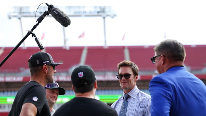 Sep 29, 2024; Tampa, Florida, USA;   Fox NFL broadcaster and former NFL quarterback Tom Brady speaks to Tampa Bay Buccaneers general manager Jason Licht before a game against the Philadelphia Eagles at Raymond James Stadium. Mandatory Credit: Nathan Ray Seebeck-Imagn Images