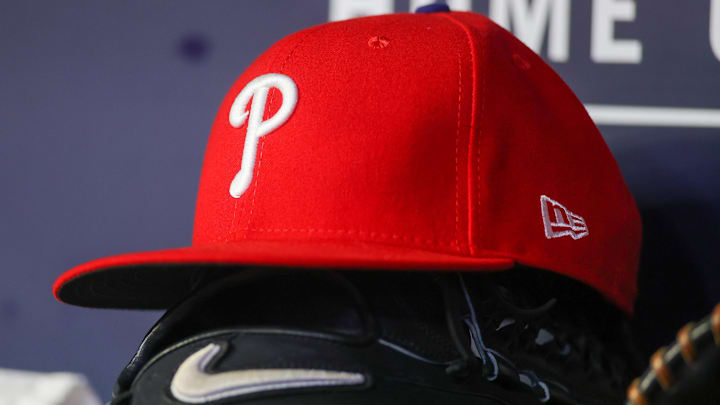 May 26, 2023; Atlanta, Georgia, USA; A detailed view of a Philadelphia Phillies hat and glove on the bench against the Atlanta Braves in the seventh inning at Truist Park. 