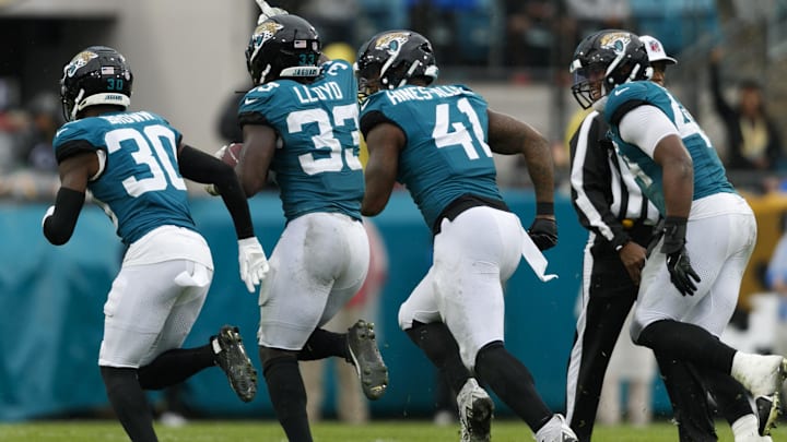Dec 29, 2024; Jacksonville, Florida, USA; Jacksonville Jaguars linebacker Devin Lloyd (33) celebrates an interception with cornerback Montaric Brown (30), defensive end Josh Hines-Allen (41) and defensive end Travon Walker (44) against the Tennessee Titans during the second quarter at EverBank Stadium. Mandatory Credit: Morgan Tencza-Imagn Images