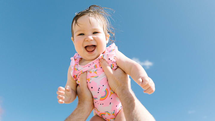 A happy baby enjoying a beach day in Hawaii.