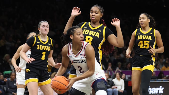 Dec 20, 2025; Brooklyn, New York, USA; UConn Huskies guard Kk Arnold (2) looks to pass the ball against Iowa Hawkeyes guard Taylor Stremlow (1), guard Journey Houston (8) and forward Hannah Stuelke (45) during the second half at Barclays Center. Mandatory Credit: Pamela Smith-Imagn Images