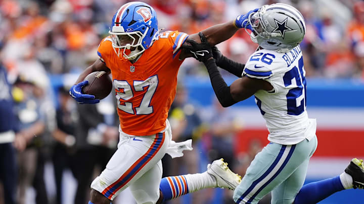 Oct 26, 2025; Denver, Colorado, USA; Denver Broncos running back J.K. Dobbins (27) runs against Dallas Cowboys cornerback DaRon Bland (26) in the first half at Empower Field at Mile High. Oct 26, 2025; Denver, Colorado, USA; Denver Broncos running back J.K. Dobbins (27) runs against Dallas Cowboys cornerback DaRon Bland (26) in the first half at Empower Field at Mile High.