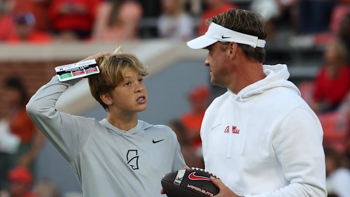 Ole Miss Rebels coach Lane Kiffin (right) talks with his son Knox before a game against the Auburn Tigers at Jordan-Hare Stadium.