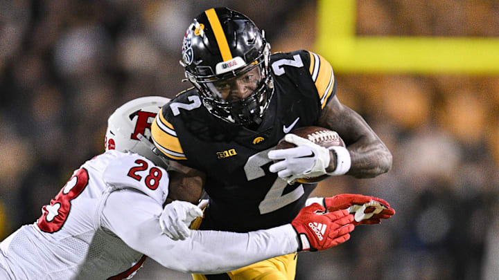 Nov 11, 2023; Iowa City, Iowa, USA; Iowa Hawkeyes running back Kaleb Johnson (2) runs the ball as Rutgers Scarlet Knights linebacker Dariel Djabome (28) goes for the tackle during the fourth quarter at Kinnick Stadium. Mandatory Credit: Jeffrey Becker-Imagn Images