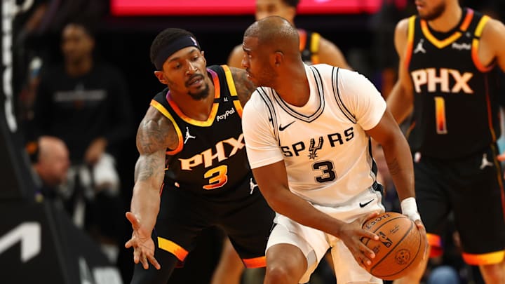 Dec 3, 2024; Phoenix, Arizona, USA; San Antonio Spurs guard Chris Paul (right) controls the ball against Phoenix Suns guard Bradley Beal in the second half of an NBA Cup game at Footprint Center. Mandatory Credit: Mark J. Rebilas-Imagn Images