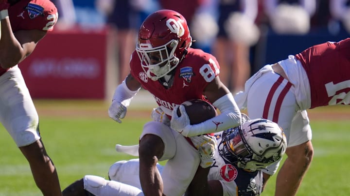 Oklahoma Sooners wide receiver Zion Ragins (81) is brought down by Navy Midshipmen safety Kenneth McShan (0) during the Armed Forces Bowl football game between the University of Oklahoma Sooners (OU) and the Navy Midshipmen at Amon G. Carter Stadium in Fort Worth, Texas, Friday, Dec. 27, 2024. Navy won 21-20.