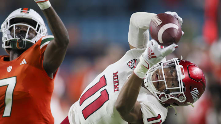 Sep 1, 2023; Miami Gardens, Florida, USA; Miami Redhawks wide receiver Javon Tracy (11) catches the football but lands out of bounds ahead of Miami Hurricanes defensive back Davonte Brown (7) during the fourth quarter at Hard Rock Stadium. Mandatory Credit: Sam Navarro-Imagn Images