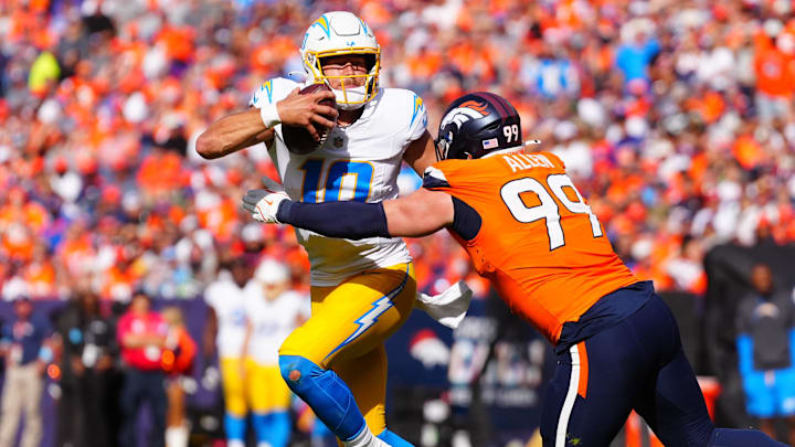 Oct 13, 2024; Denver, Colorado, USA; Denver Broncos defensive end Zach Allen (99) reaches for Los Angeles Chargers quarterback Justin Herbert (10) in the second quarter at Empower Field at Mile High. 
