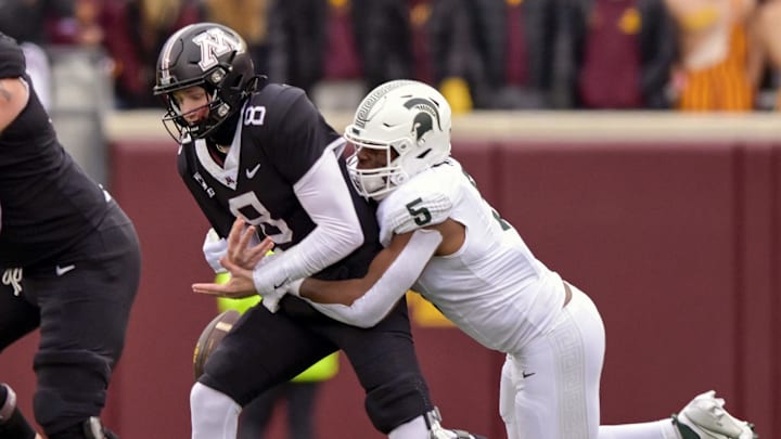 Oct 28, 2023; Minneapolis, Minnesota, USA; Minnesota Golden Gophers quarterback Athan Kaliakmanis (8) is sacked by Michigan State Spartans linebacker Jordan Hall (5) during the first quarter at Huntington Bank Stadium. Mandatory Credit: Nick Wosika-Imagn Images