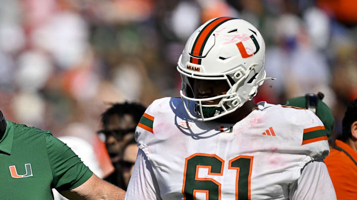 Nov 1, 2025; Dallas, Texas, USA;  Miami Hurricanes head coach Mario Cristobal talks to offensive lineman Anez Cooper (73) and offensive lineman Francis Mauigoa (61) during the second half against the SMU Mustangs at Gerald J. Ford Stadium. Mandatory Credit: Jerome Miron-Imagn Images