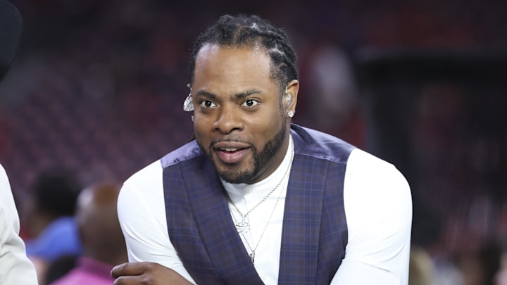 Television analyst Richard Sherman looks on before the game