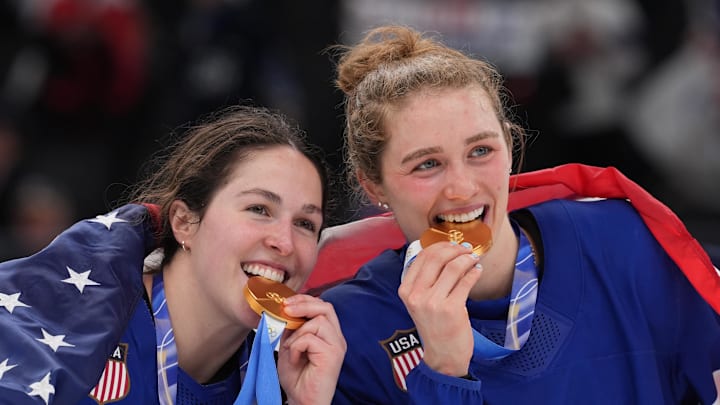 Feb 19, 2026; Milan, Italy; Minnesota forward Abbey Murphy, left, and Wisconsin defender Caroline Harvey celebrate winning the gold medal after defeating Canada during the Milano Cortina 2026 Olympic Winter Games at Milano Santagiulia Ice Hockey Arena. 
