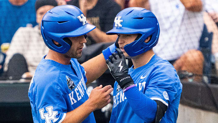 Jun 19, 2024; Omaha, NE, USA; Kentucky Wildcats left fielder Ryan Waldschmidt (21) talks with third baseman Mitchell Daly (2) after scoring a run against the Florida Gators during the first inning at Charles Schwab Field Omaha. Mandatory Credit: Dylan Widger-Imagn Images Jun 19, 2024; Omaha, NE, USA; Kentucky Wildcats left fielder Ryan Waldschmidt (21) talks with third baseman Mitchell Daly (2) after scoring a run against the Florida Gators during the first inning at Charles Schwab Field Omaha. Mandatory Credit: Dylan Widger-Imagn Images
