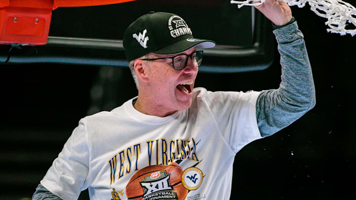 Mar 8, 2026; Kansas City, MO, USA; West Virginia Mountaineers coach Mark Kellogg cuts down the net after the game against the TCU Horned Frogs at T-Mobile Center. Mandatory Credit: William Purnell-Imagn Images