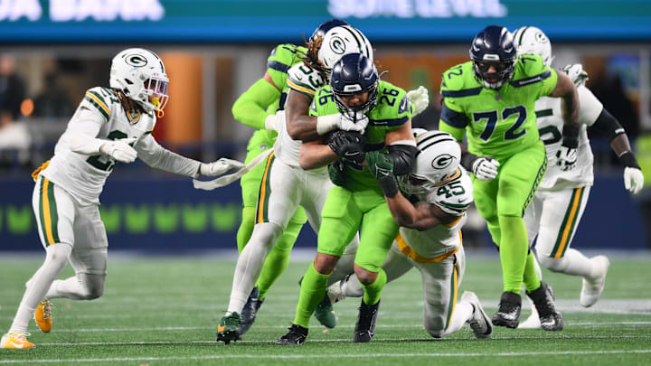 Dec 15, 2024; Seattle, Washington, USA; Green Bay Packers defensive end Arron Mosby (53) and Green Bay Packers linebacker Eric Wilson (45) tackle Seattle Seahawks running back Zach Charbonnet (26) during the second half at Lumen Field.