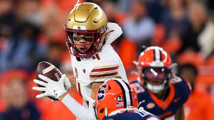 Nov 29, 2025; Syracuse, New York, USA; Boston College Eagles wide receiver Reed Harris (4) runs with the ball after a catch in front of Syracuse Orange defensive back Braheem Long Jr. (0) during the first half at the JMA Wireless Dome. Mandatory Credit: Rich Barnes-Imagn Images