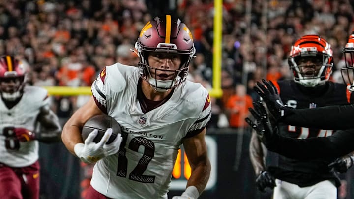 Washington Commanders wide receiver Luke McCaffrey (12) picks up yards around Cincinnati Bengals safety Geno Stone (22) Monday, September 23, 2024 at Paycor Stadium.