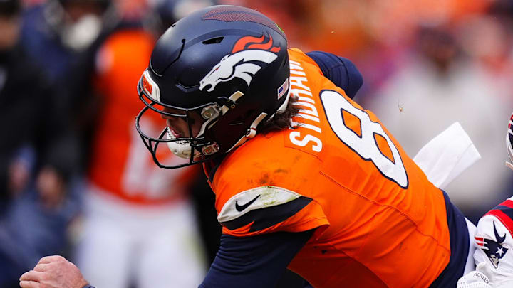 Jan 25, 2026; Denver, CO, USA; Denver Broncos quarterback Jarrett Stidham (8) rushes the ball past New England Patriots cornerback Marcus Jones (25) during the first half in the 2026 AFC Championship Game at Empower Field at Mile High. Mandatory Credit: Ron Chenoy-Imagn Images