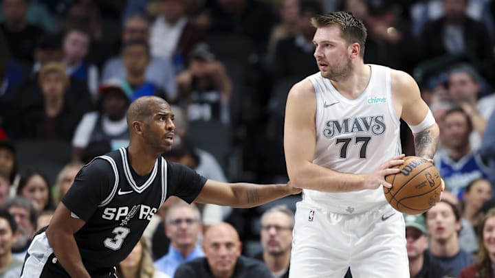 Nov 16, 2024; Dallas, Texas, USA;  Dallas Mavericks guard Luka Doncic (77) looks to pass as San Antonio Spurs guard Chris Paul (3) defends during the first quarter at American Airlines Center. Mandatory Credit: Kevin Jairaj-Imagn Images