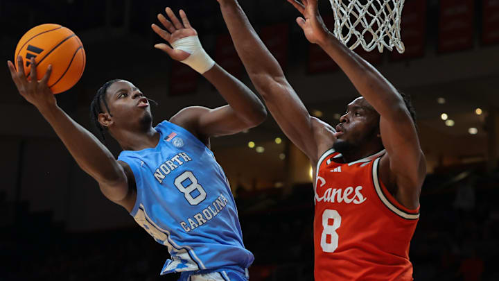 Feb 10, 2026; Coral Gables, Florida, USA; North Carolina Tar Heels forward Caleb Wilson (8) drives to the basket against Miami Hurricanes center Ernest Udeh Jr. (8) during the second half at Watsco Center. Mandatory Credit: Sam Navarro-Imagn Images