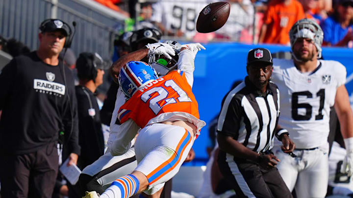 Oct 6, 2024; Denver, Colorado, USA; Denver Broncos cornerback Riley Moss (21) breaks up a pass intended for Las Vegas Raiders wide receiver Tre Tucker (11) in the first half at Empower Field at Mile High. 