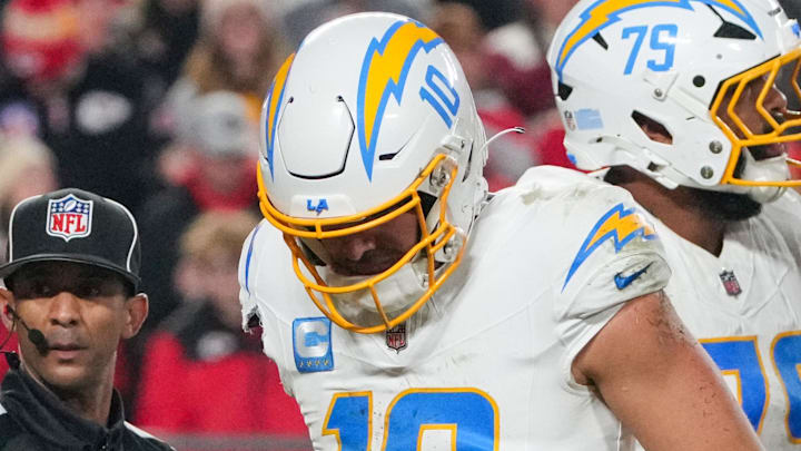 Dec 8, 2024; Kansas City, Missouri, USA; Los Angeles Chargers quarterback Justin Herbert (10) limps after being sacked by Kansas City Chiefs defensive end Charles Omenihu (90) (not pictured) during the first half at GEHA Field at Arrowhead Stadium. Mandatory Credit: Denny Medley-Imagn Images