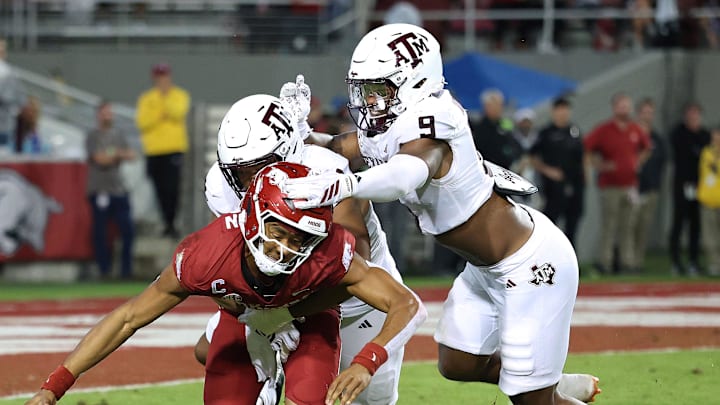 Oct 18, 2025; Fayetteville, Arkansas, USA; Texas A&M Aggies defensive end Dayon Hayes (50) sacks Arkansas Razorbacks quarterback Taylen Green (10) during the fourth quarter as Aggies defensive end Cashius Howell (9) closes in at Donald W. Reynolds Razorback Stadium. Mandatory Credit: Nelson Chenault-Imagn Images