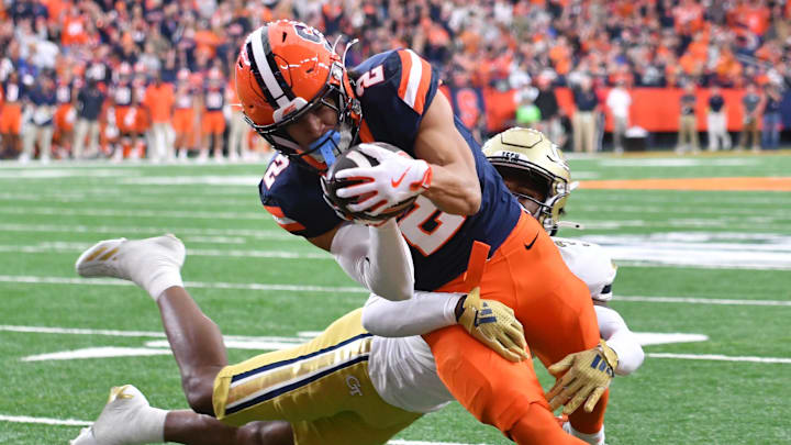 Sep 7, 2024; Syracuse, New York, USA; Syracuse Orange wide receiver Trebor Pena (2) scores a touchdown as Georgia Tech Yellow Jackets defensive back Ahmari Harvey (3) tries to stop him in the first quarter at JMA Wireless Dome. Mandatory Credit: Mark Konezny-Imagn Images