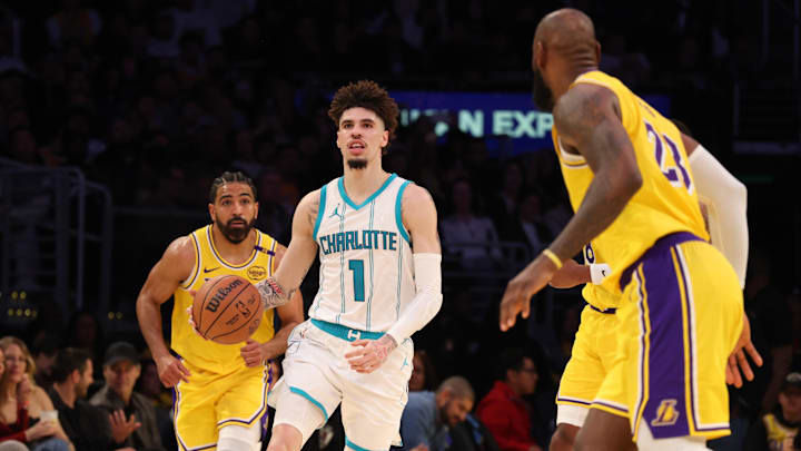 Feb 19, 2025; Los Angeles, California, USA; Charlotte Hornets guard LaMelo Ball (1) dribbles against Los Angeles Lakers forward LeBron James (23) during the third quarter at Crypto.com Arena. Mandatory Credit: Jason Parkhurst-Imagn Images