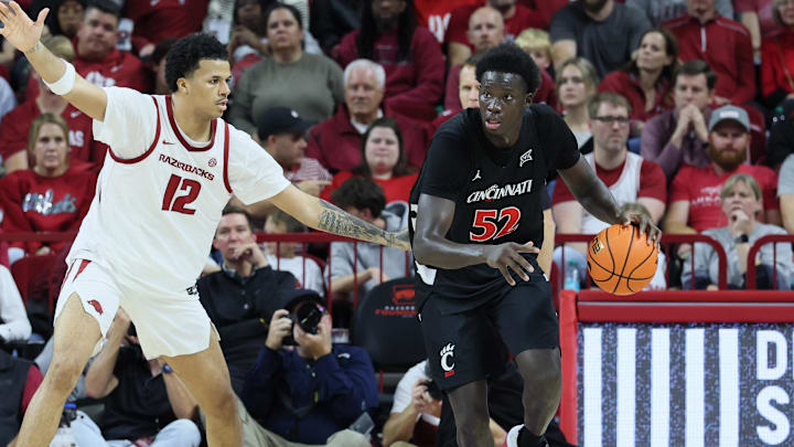Oct 24, 2025; Fayetteville, AR, USA; Arkansas Razorbacks forward Malique Twin (12) defends against Cincinnati Bearcats center Moustapha Thiam (52) at Bud Walton Arena. Mandatory Credit: Nelson Chenault-Imagn Images