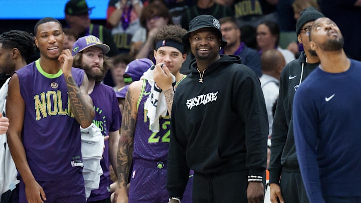 Mar 30, 2025; New Orleans, Louisiana, USA; New Orleans Pelicans forward Zion Williamson, wearing street clothes and hat, smiles as his team gains a lead late during the fourth quarter against the Charlotte Hornets at Smoothie King Center. Mandatory Credit: Matthew Hinton-Imagn Images Mar 30, 2025; New Orleans, Louisiana, USA; New Orleans Pelicans forward Zion Williamson, wearing street clothes and hat, smiles as his team gains a lead late during the fourth quarter against the Charlotte Hornets at Smoothie King Center. Mandatory Credit: Matthew Hinton-Imagn Images