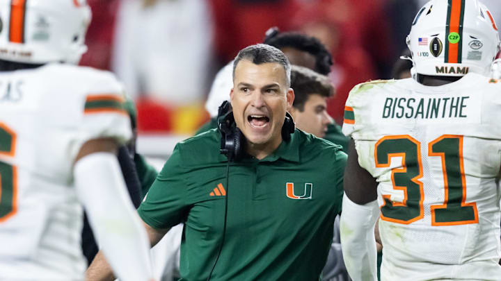Jan 19, 2026; Miami Gardens, FL, USA; Miami Hurricanes head coach Mario Cristobal with linebacker Wesley Bissainthe (31) against the Indiana Hoosiers during the College Football Playoff National Championship game at Hard Rock Stadium. Mandatory Credit: Mark J. Rebilas-Imagn Images